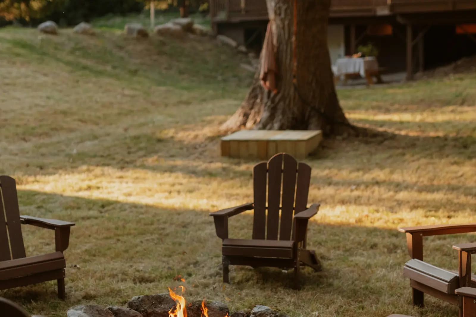 Backyard entertaining space with paver patio, fire pit, and layered landscape design