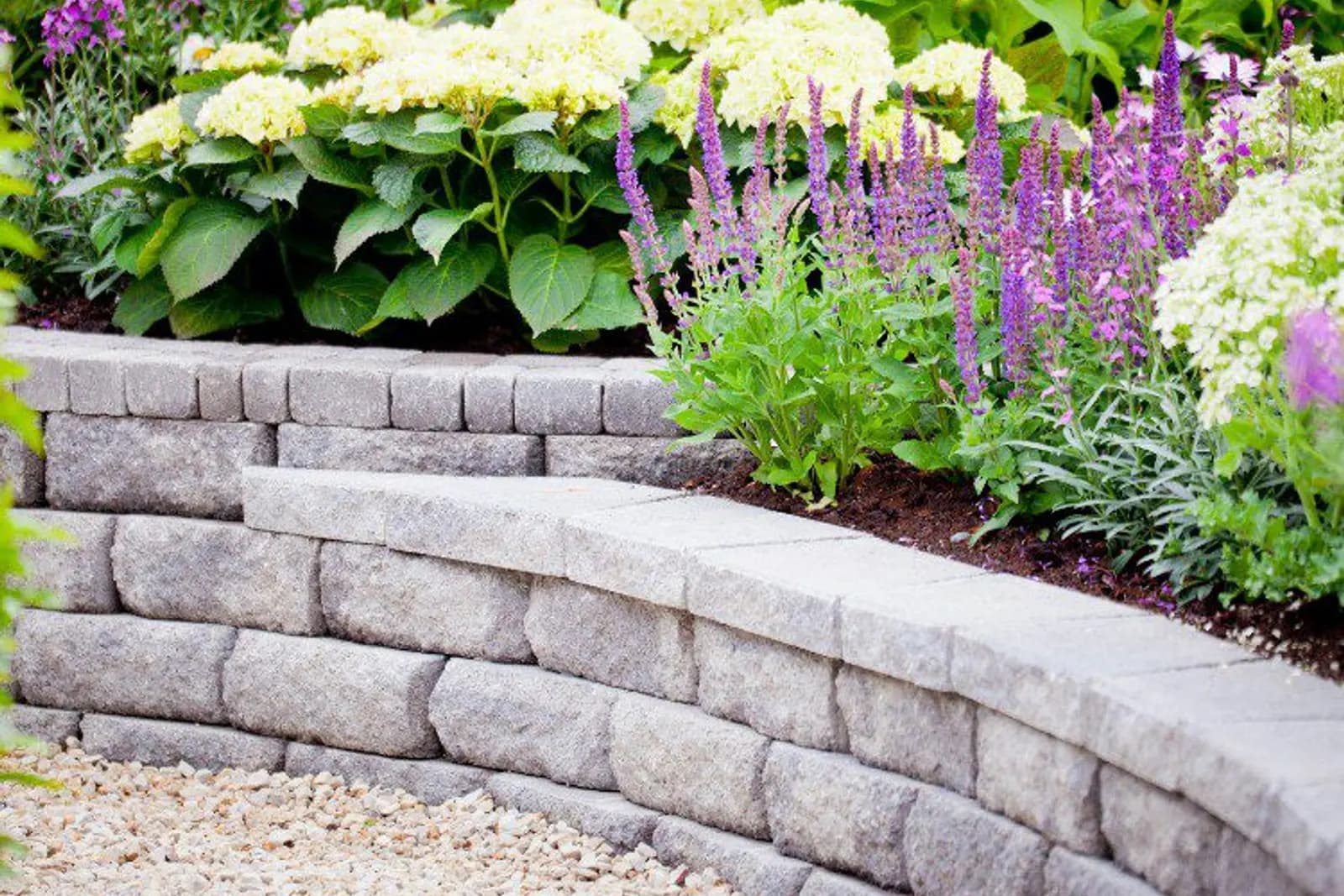 Tiered concrete block retaining wall topped with flowering plants